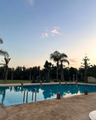 Villa avec piscine et palmiers au crépuscule