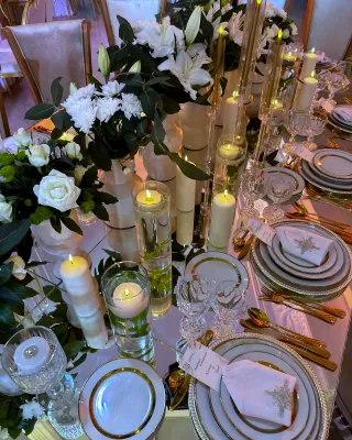 Longue table dressée, bougies et fleurs blanches